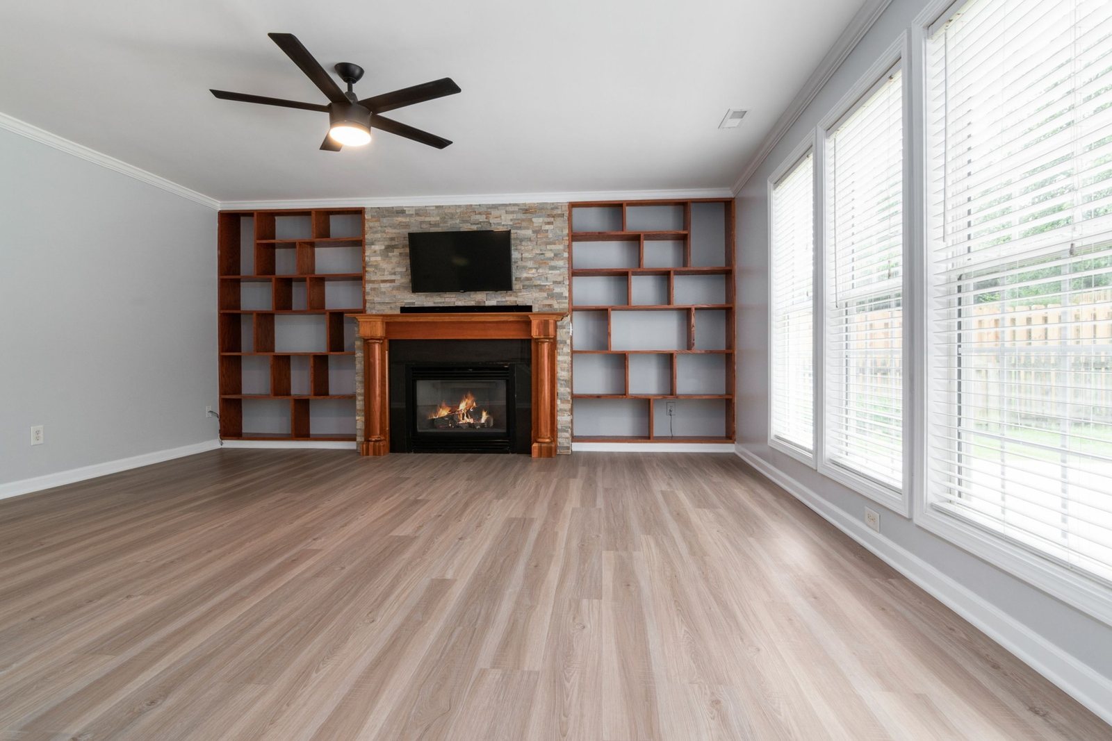 Empty room with fireplace and built-in shelving cleaned
