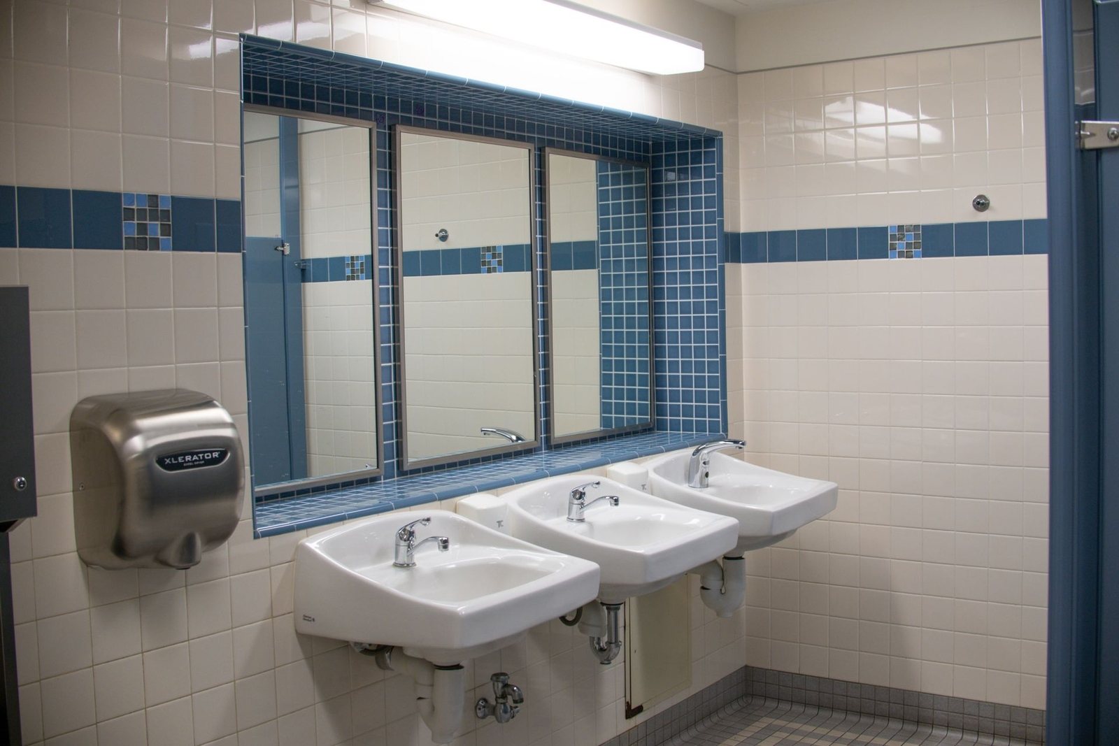 Commercial washroom with sinks and mirrors cleaned